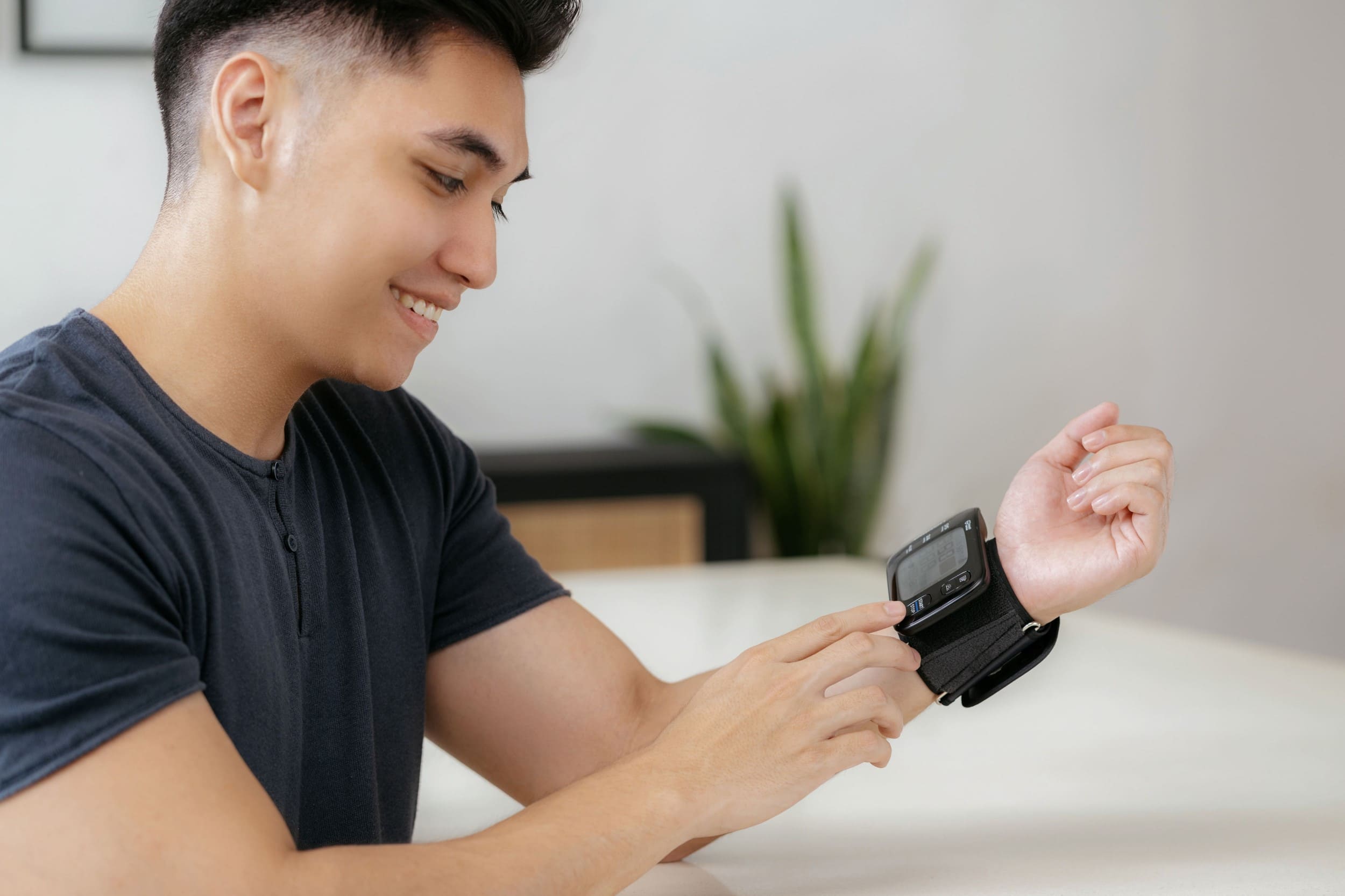 A man using OMRON wrist blood pressure monitor to measure blood pressure.
