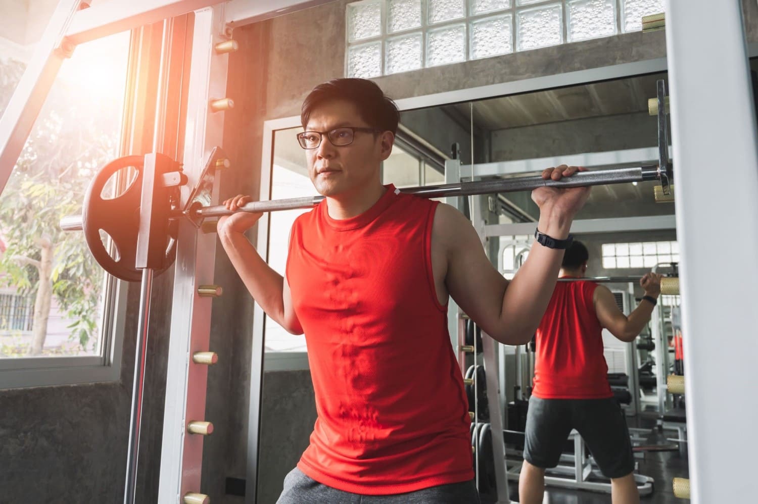 A man performing barbell exercises in a gym.