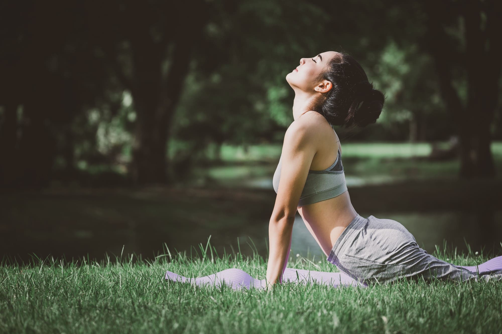 A woman doing yoga on the grass.