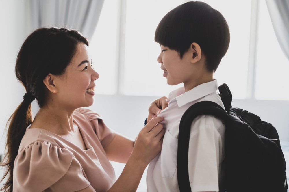 A mother sending her child off to school.