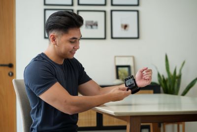A man checking his blood pressure reading on a monitor.