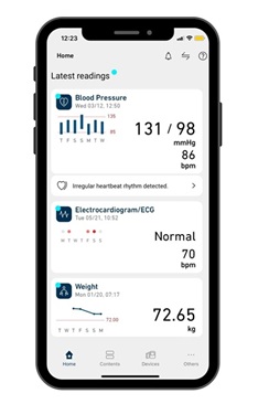 OMRON connect app homepage with health insights shown on phone screen.