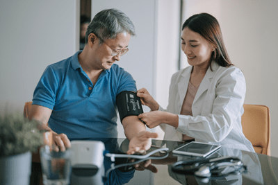 A doctor helping a patient adjust his cuff to measure his blood pressure.