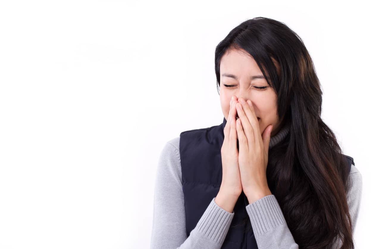 Young woman sneezing.